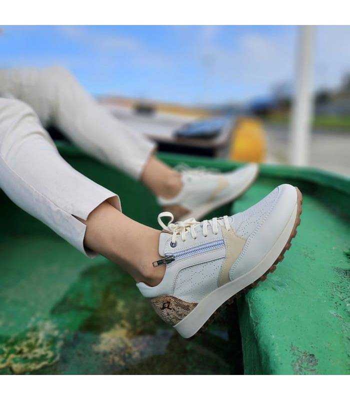 Zapato deportivo beige con cremallera de Kangarros puesto en modelo posando en una barca