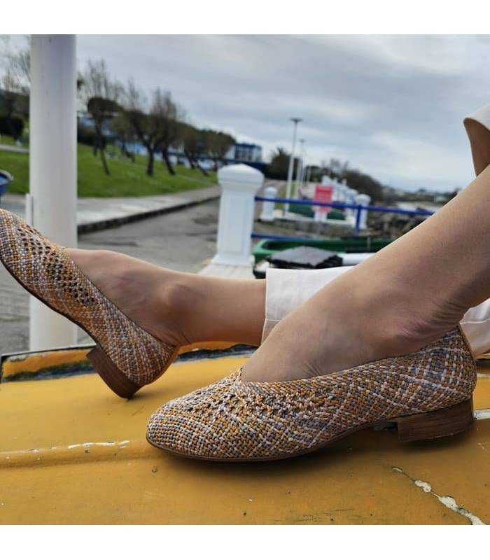 zapatos salon de rejilla beige con toques mostaza puestos en los pies
