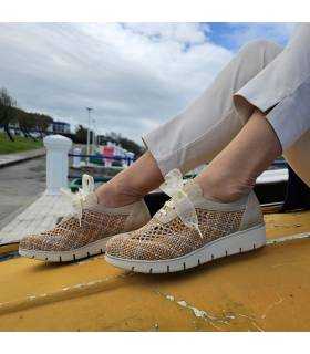 Modelo posando en una barca amarilla con los zapatos de rejilla con cordones de Nival Woman rebajas