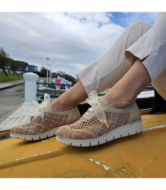 Modelo posando en una barca amarilla con los zapatos de rejilla con cordones de Nival Woman rebajas
