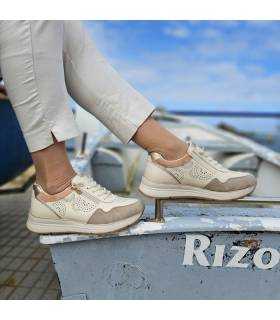 modelo posando en una barca blanca con los zapatos de piel calada de Treintas