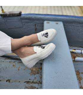 Modelo posando con los pies cruzados con los mocasines de cuña de Laura Azaña