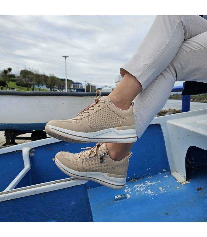 imagen de mujer con las piernas cruzadas posando con las zapatillas deportivas Billion de Skechers puestas