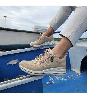 Imagen de los dos perfiles de las zapatillas deportivas con cuña de Skechers puestas en los pies.