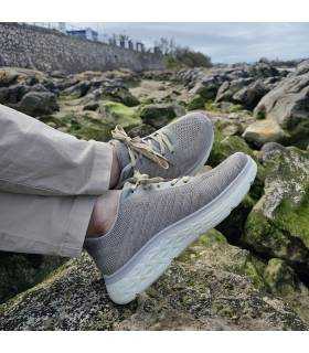 hombre posando con los pies cruzados con las zapatillas deportivas Chalon beige de Jhayber