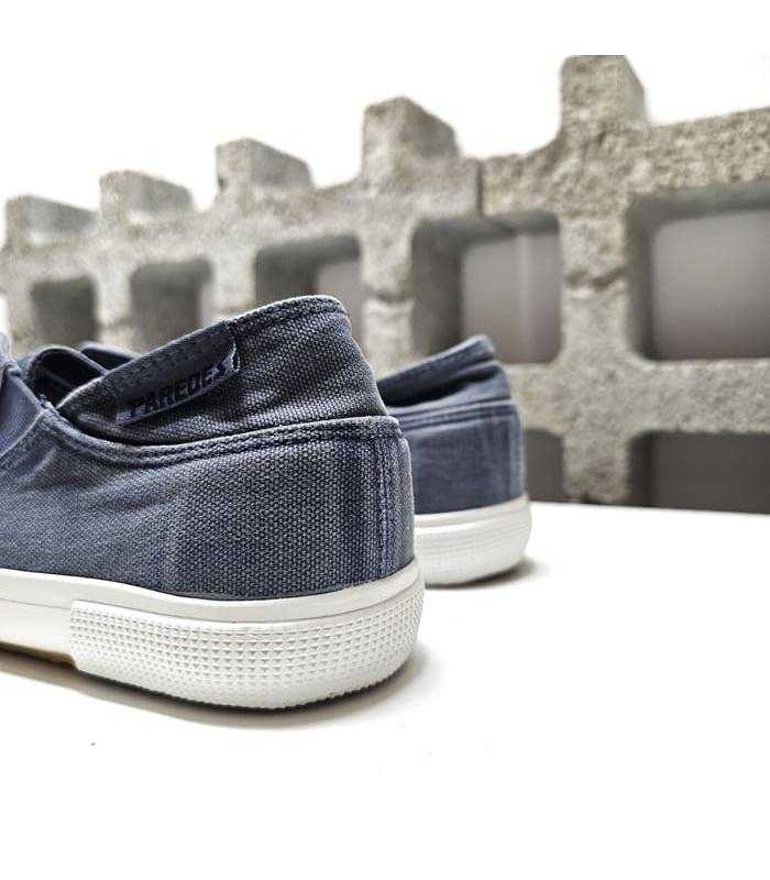 Parte trasera de la zapatilla con acabado en lona lavada azul. Diseño cómodo y fresco para el verano.