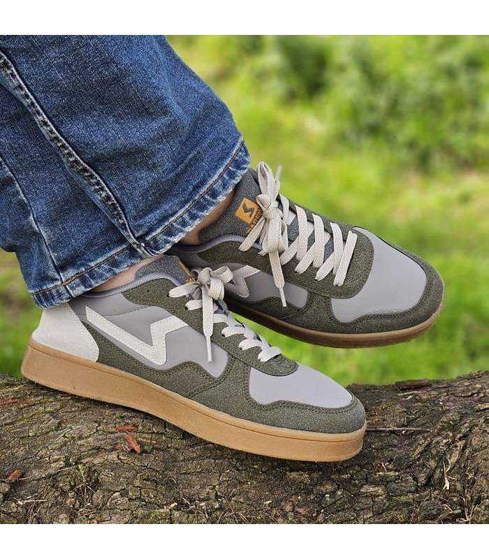 Pies cruzados con las zapatillas verdes de Paredes puestas