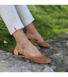 sandalias cerradas de piel color marrón puestas en modelo posando de perfil.