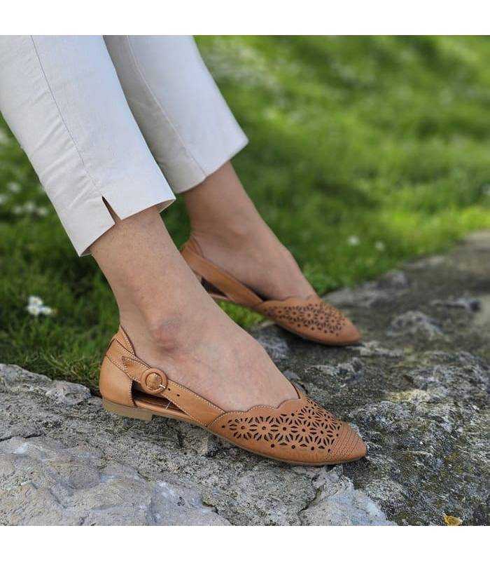 sandalias cerradas de piel color marrón puestas en modelo posando de perfil.