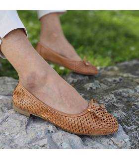 Zapato bailarina puesto en modelo posando en un jardín