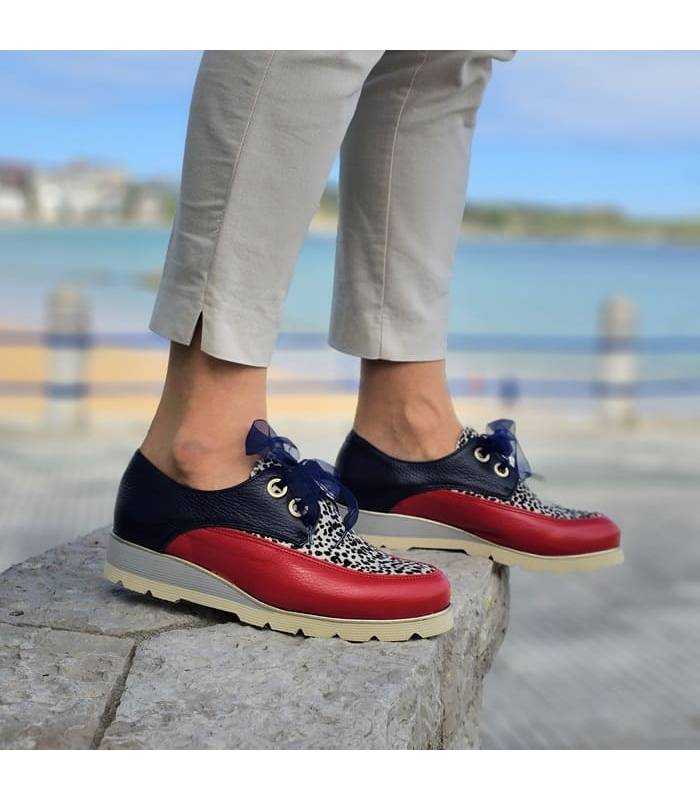 foto de perfil de los zapatos de cordones azules puestos en modelo junto a la playa