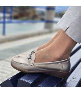 zapato mocasín puesto en modelo posando en un banco junto al mar