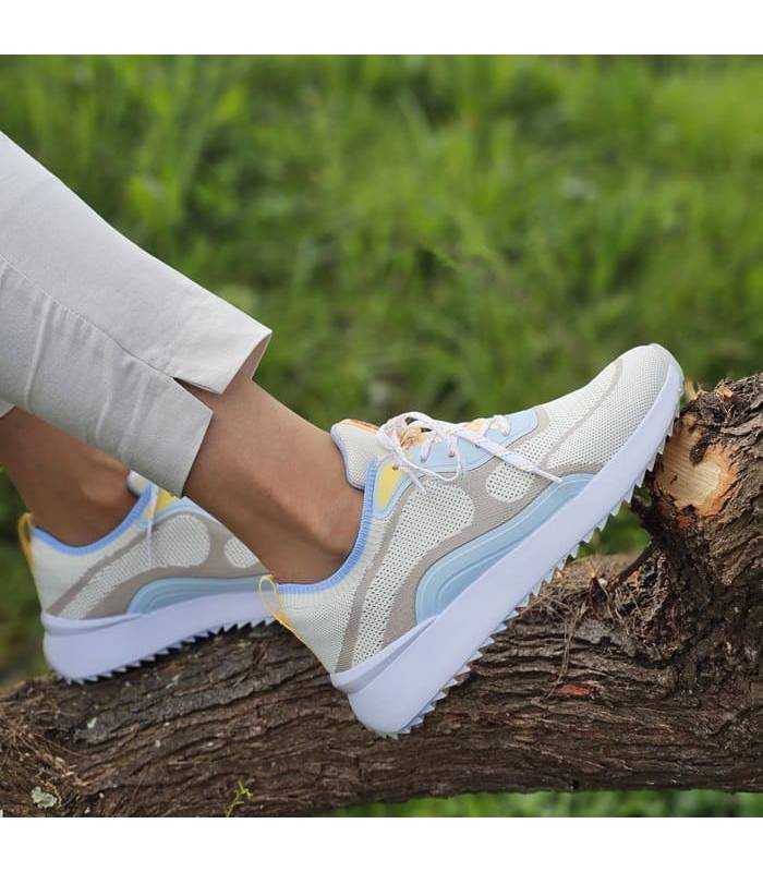mujer luciendo con pantalón beige los deportivos con cuña de Kangaroos de rebajas