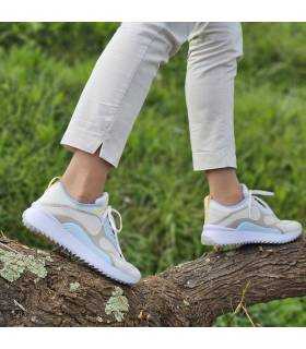 Zapatilas deportivas taupe beige de kangaroos puestas en modelo caminando sobre una rama de un árbol