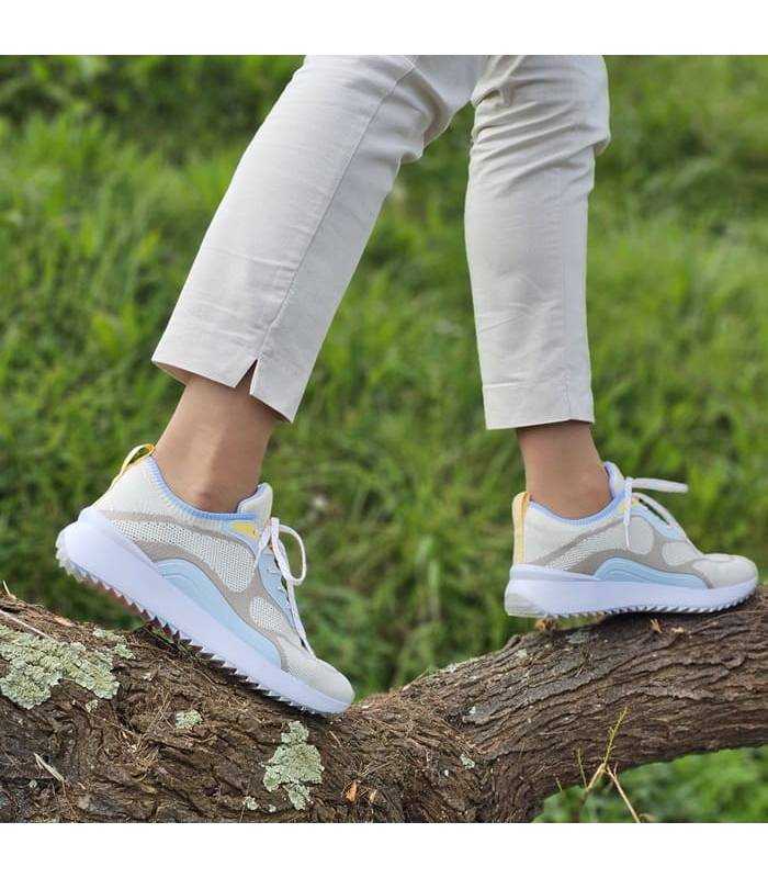 Zapatilas deportivas taupe beige de kangaroos puestas en modelo caminando sobre una rama de un árbol