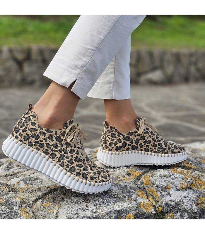 Mujer posando con los zapatos deportivos de animal print