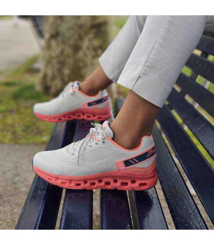 Zapatillas running mujer J'hayber blanco posando con ellos modelo e un banco