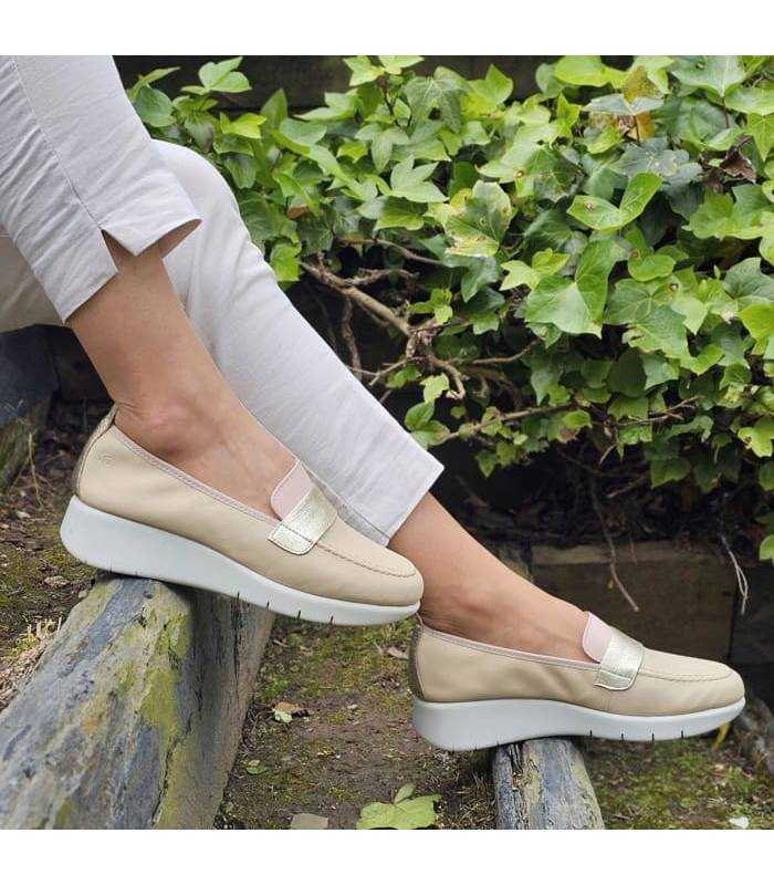 modelo bajando escaleras con los mocasínes mujer cuña Flex & Go en piel beige puestos