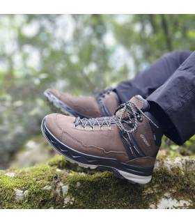 Hombre en el monte posando con las botas marrones de trekking de Grisport puestas