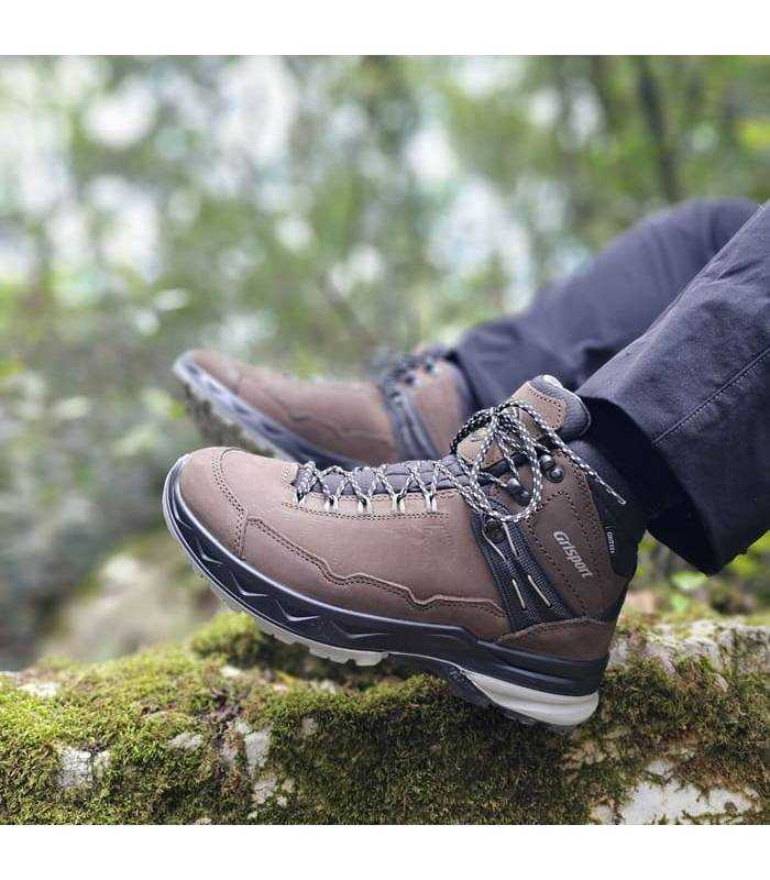 Hombre en el monte posando con las botas marrones de trekking de Grisport puestas