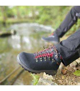 bota de trekking gris de Chiruca puesta en un hombre junto al rio