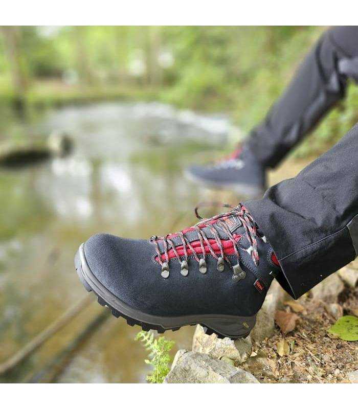bota de trekking gris de Chiruca puesta en un hombre junto al rio