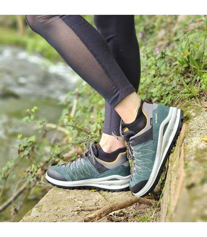 mujer posando junto al rio con las zapatillas de senderismo unisex de Grisport