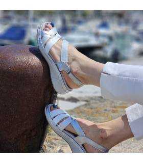 sandalia blanca con plata comoda puesta en los pies de Suave