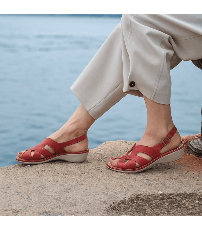 sandalia Ada puesta en los pies de una mujer posando junto al mar