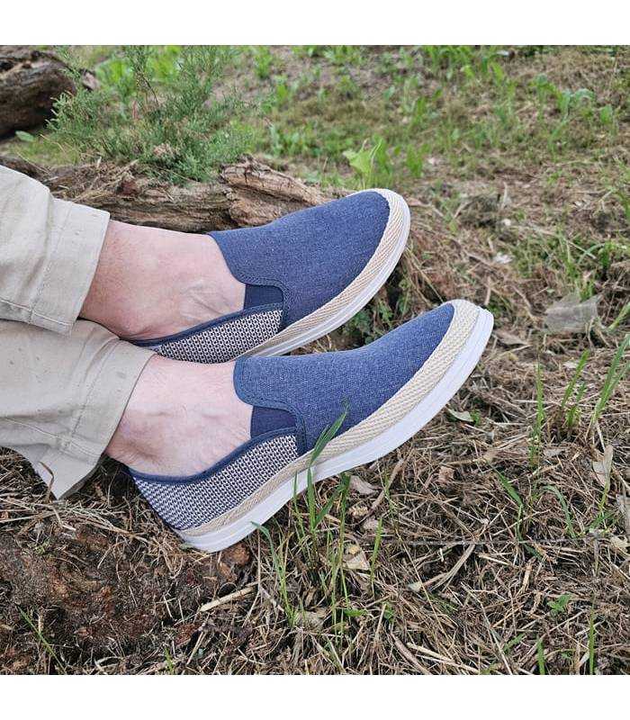 hombre posando con los pies cruzados con las alpargatas en el campo