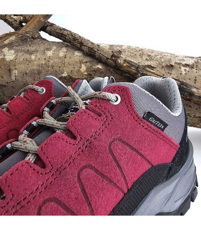 primer plano del la piel color burdeos y del cierre de cordones de la zapatilla de trekking mujer