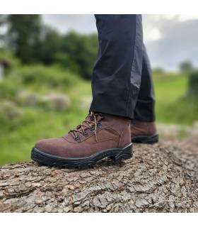Bota de trekking marrón de hombre puesta posando soibre rocas