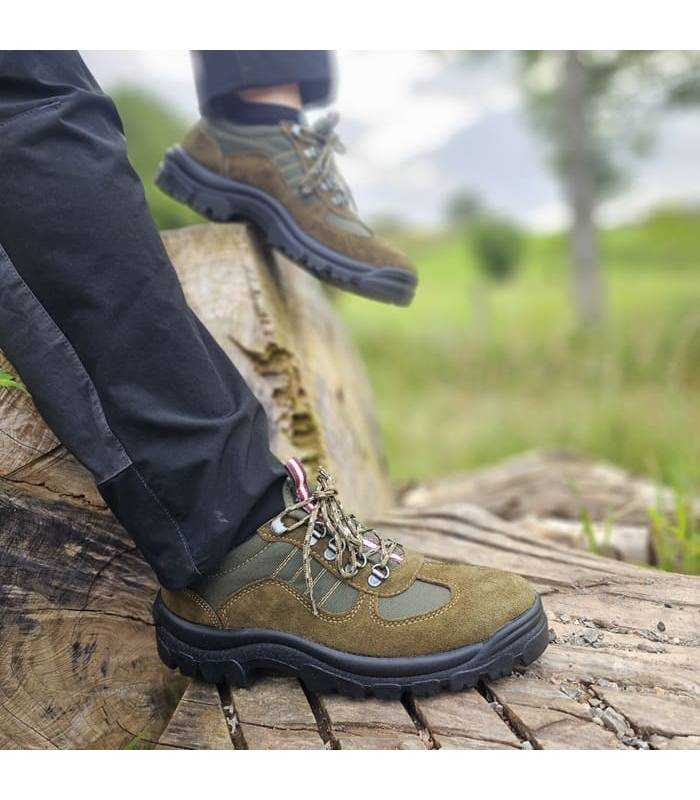 Zapatilla de senderismo verde puesta en un hombre sobre unas rocas