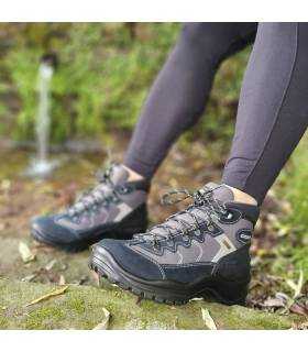 vista ltaeral de la botas impermeable de trekking puesta cerca de un rio