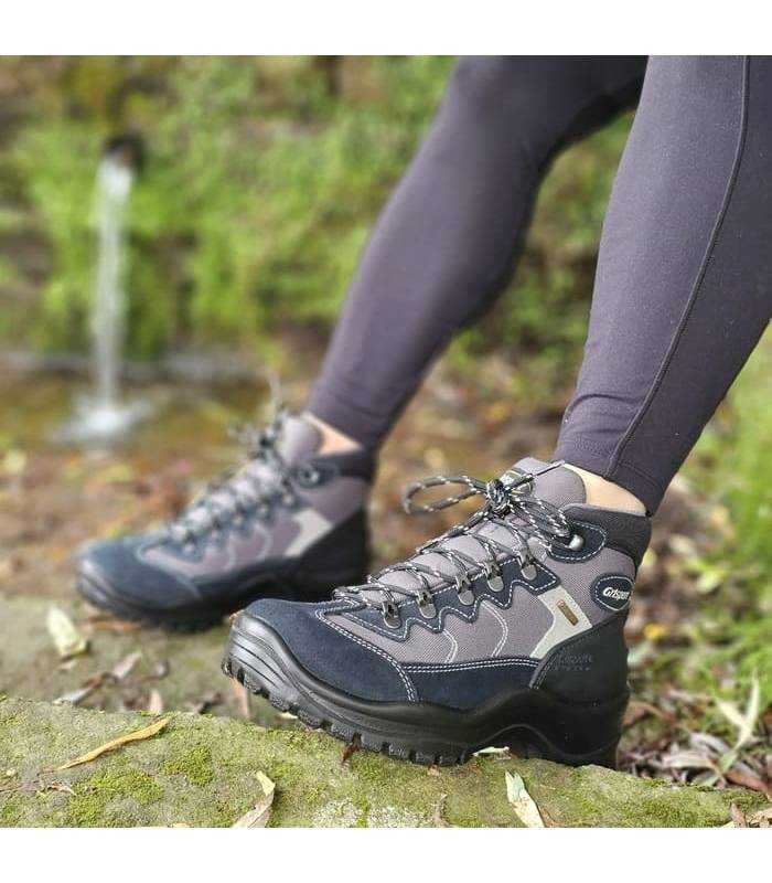 vista ltaeral de la botas impermeable de trekking puesta cerca de un rio