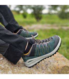 hombre posando descando sobre una roca con la zapatilla de senderismo impermeable verde de Grisport