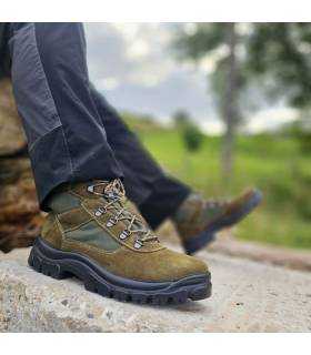 Botas de montaña verdes de hombre puesta en entorno rural