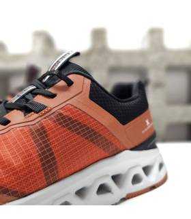 Detalle lateral: tejido transpirable naranja con refuerzos negros en zapatillas XTI hombre