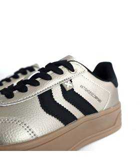 Primer plano de zapatillas XTI beige nacarado para mujer con cordones negros y logo en el lateral.