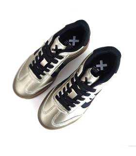 Vista desde arriba de zapatillas XTI beige nacarado para mujer con cordones negros y plataforma marrón.