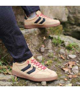 hombre sentado posando con las zapatillas casul beige de Xti