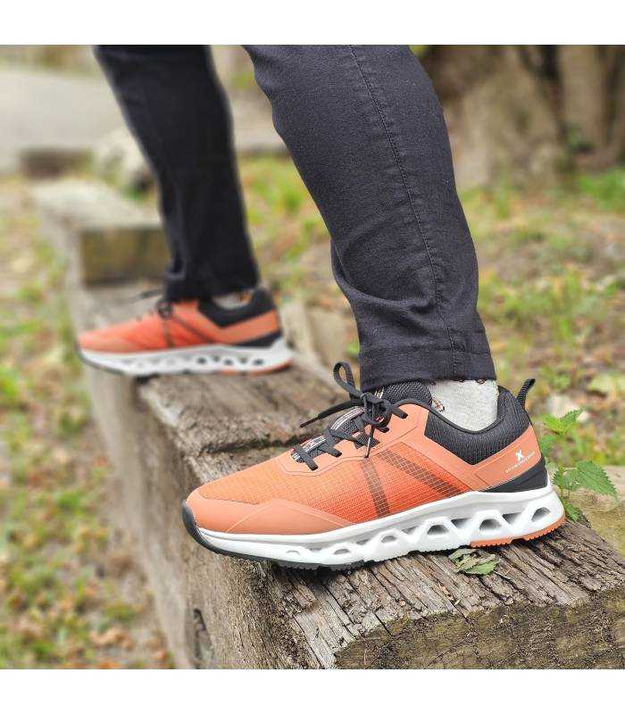 hombre posando con las zapatillas deportivas naranjas de Xti