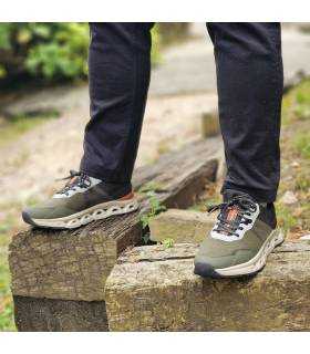 hombre posando sobre unas rocas con las zapatillas verdes de Xti