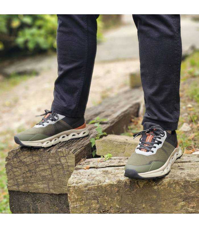 hombre posando sobre unas rocas con las zapatillas verdes de Xti