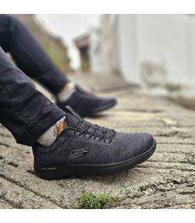 hombre posando con las zapatillas deportivas Summits negras de Skechers puestas