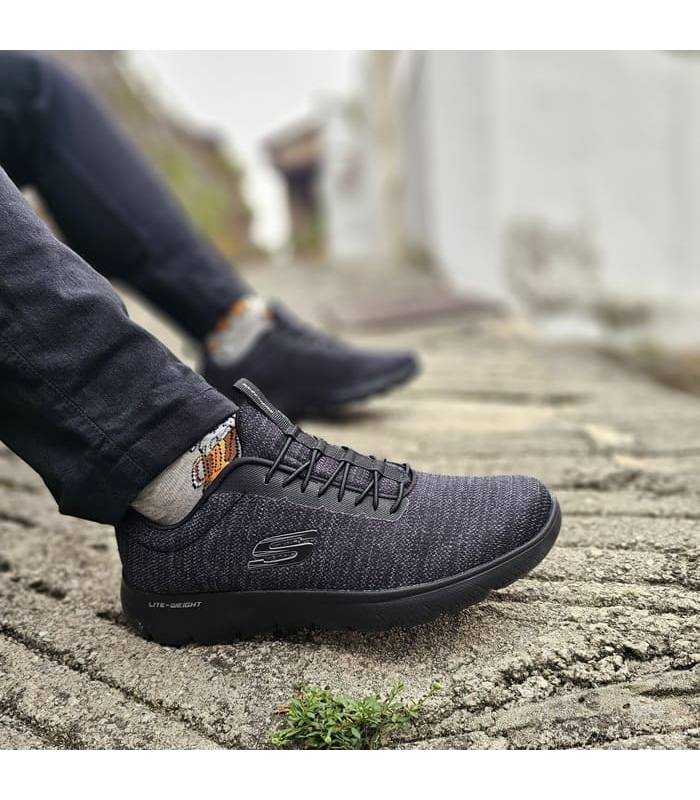 hombre posando con las zapatillas deportivas Summits negras de Skechers puestas