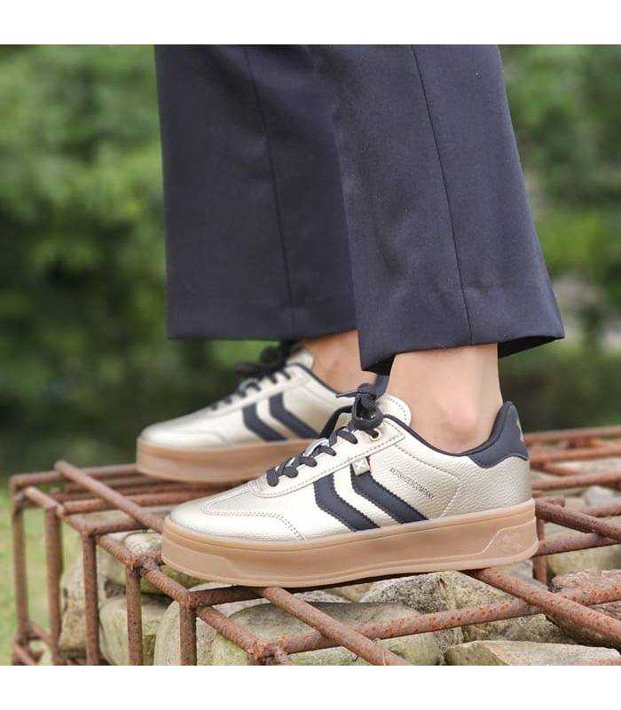 mujer posando con las zapatillas deportivas con plataforma color dorado de XTI