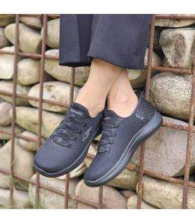 mujer posando con las zapatillas de trabajo de skechers negras silp-ins