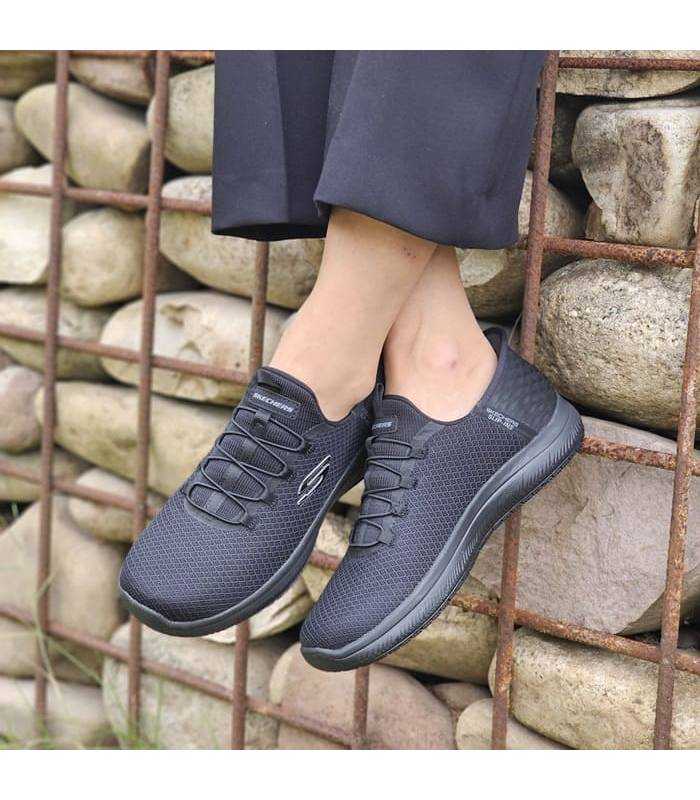 mujer posando con las zapatillas de trabajo de skechers negras silp-ins