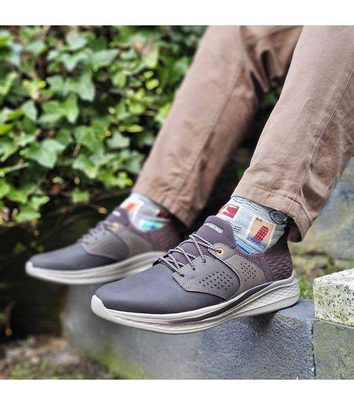 hombre con las zapatillas sekechers marrones Slip-ins marrones en unas escaleras